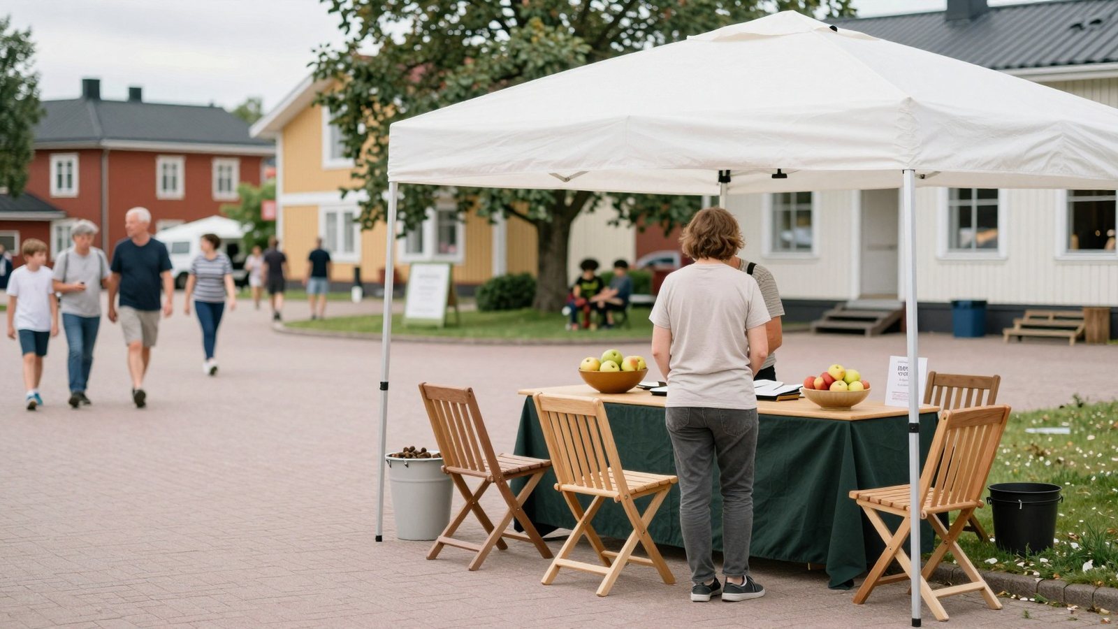 Kävijä pysähtyy juttelemaan pienen yrityksen kojulla kesätorilla, muut kulkevat ohi